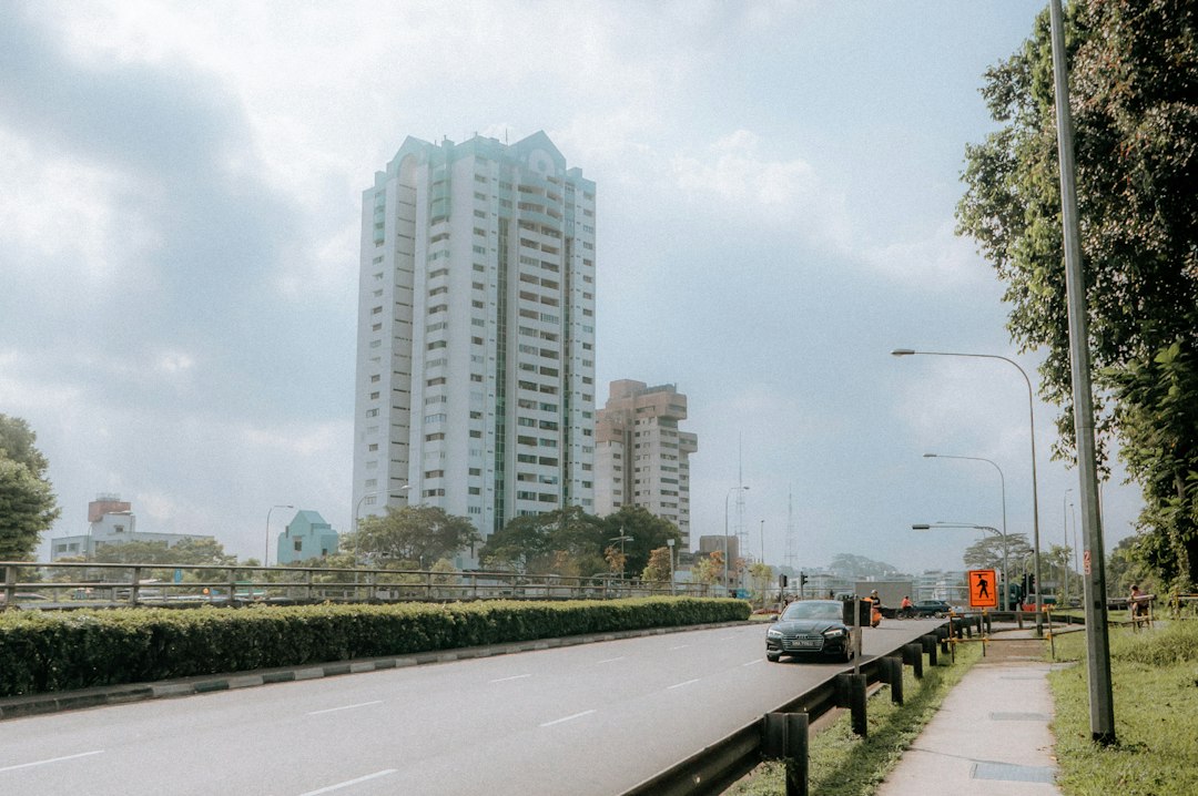 A car driving down a street next to tall buildings
